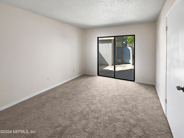 carpeted empty room with a textured ceiling