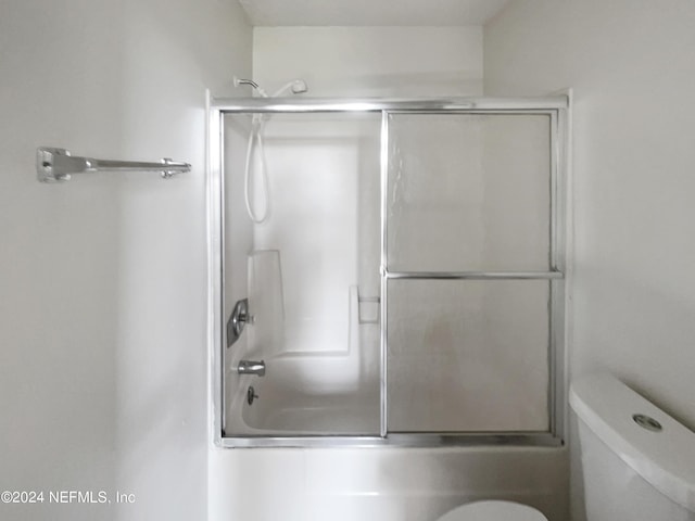 bathroom featuring shower / bath combination with glass door and toilet