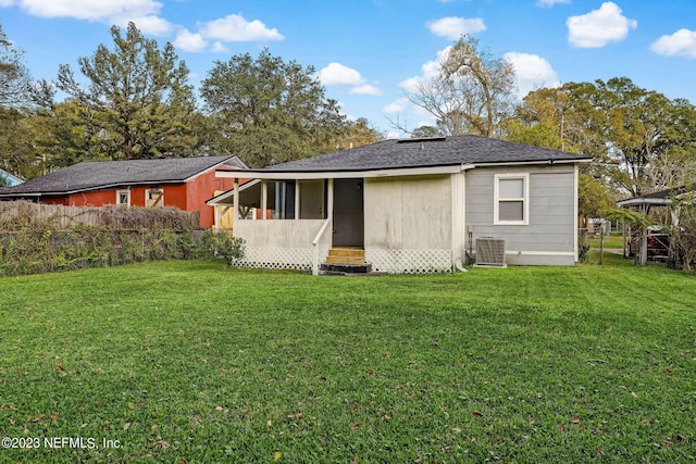 rear view of house featuring a yard and cooling unit