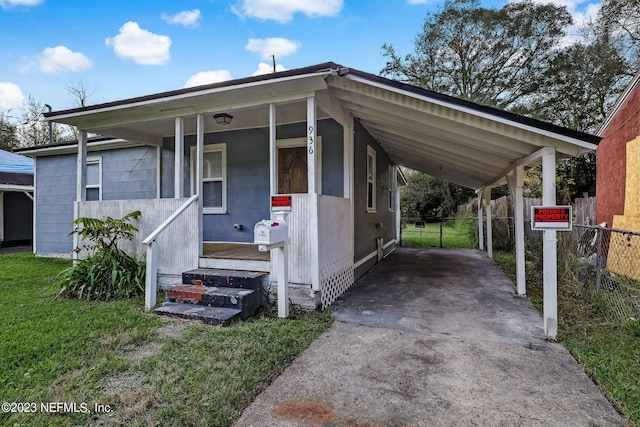 view of front of property with a carport, a porch, and a front lawn