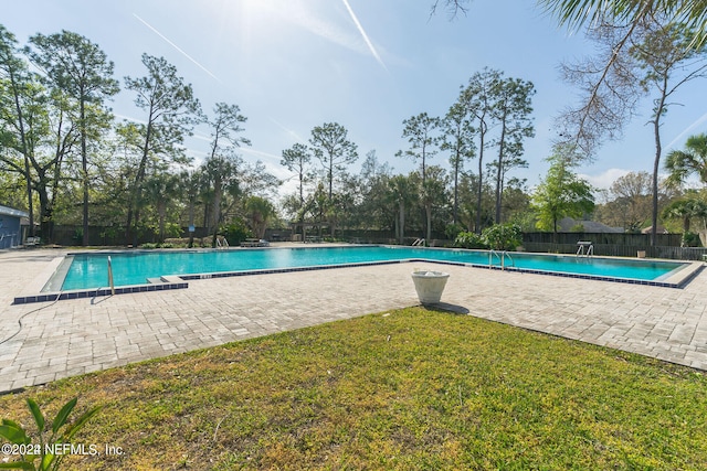 view of pool with a yard and a patio