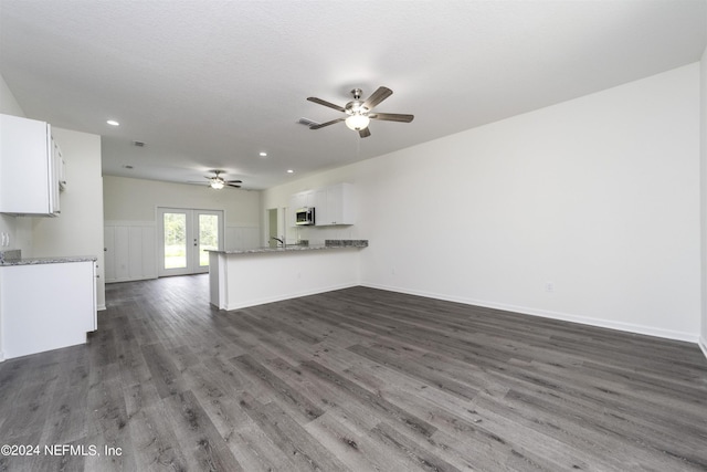 unfurnished living room featuring french doors, ceiling fan, and dark hardwood / wood-style flooring