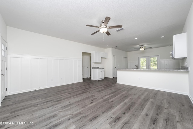 unfurnished living room featuring a textured ceiling, french doors, sink, dark hardwood / wood-style floors, and ceiling fan