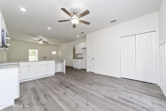 interior space featuring ceiling fan, sink, a textured ceiling, and light hardwood / wood-style flooring