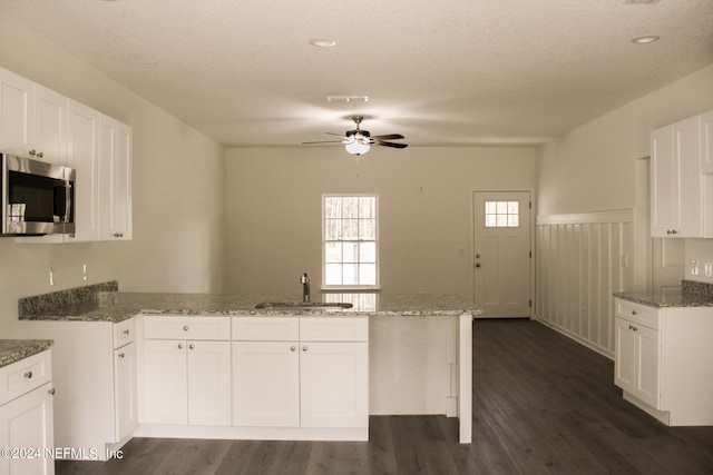 kitchen featuring sink, kitchen peninsula, and white cabinets