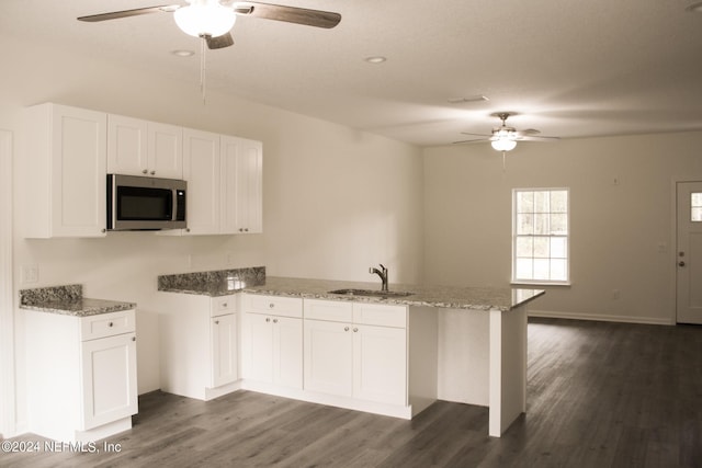 kitchen featuring kitchen peninsula, sink, white cabinetry, and dark hardwood / wood-style floors