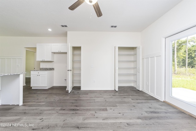 unfurnished living room featuring ceiling fan and light wood-type flooring