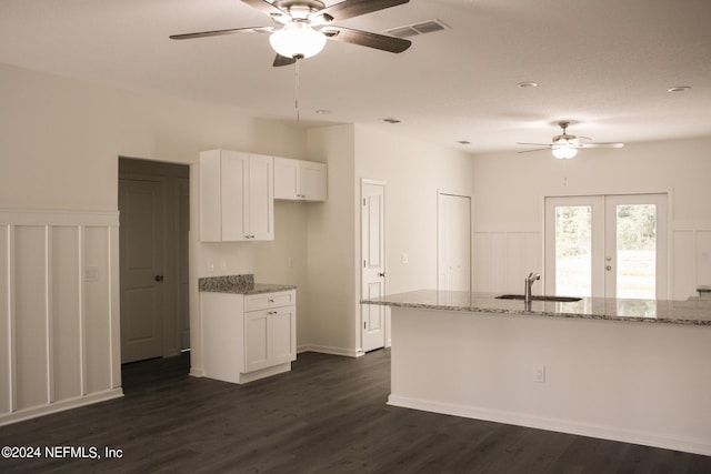 kitchen featuring white cabinets, light stone counters, dark hardwood / wood-style flooring, and sink