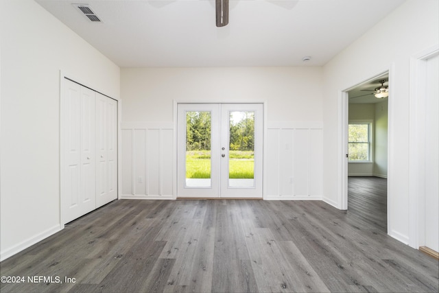 empty room with french doors, ceiling fan, and dark hardwood / wood-style flooring