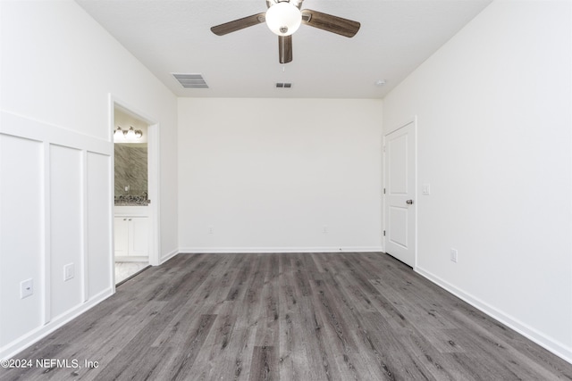 unfurnished bedroom featuring ceiling fan, dark hardwood / wood-style floors, and ensuite bath