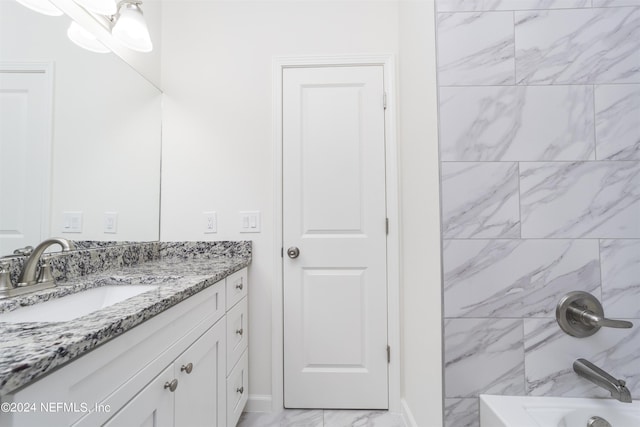 bathroom with tiled shower / bath combo and vanity