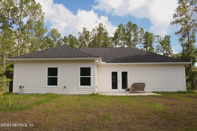 rear view of property featuring a yard and french doors