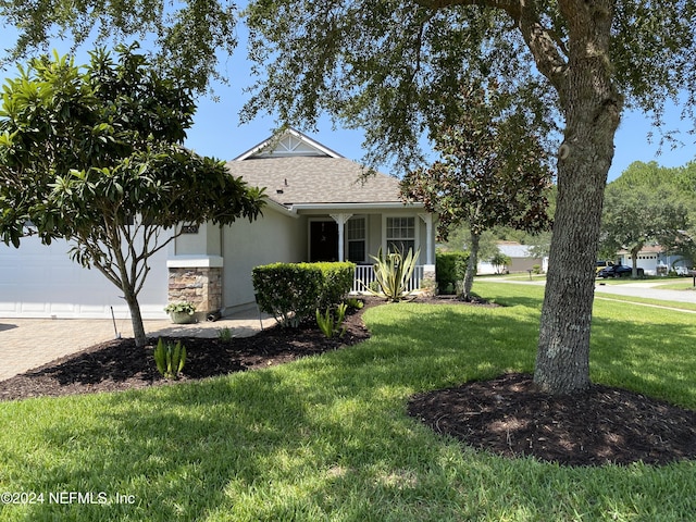 view of front of house featuring an attached garage, a shingled roof, decorative driveway, stucco siding, and a front lawn