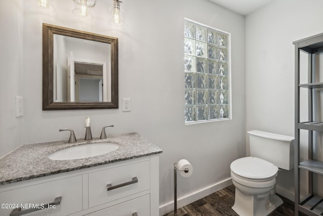 bathroom featuring vanity, hardwood / wood-style flooring, and toilet