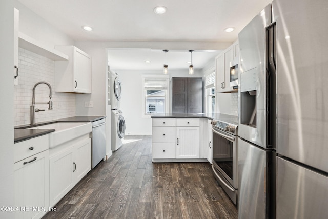 kitchen featuring white cabinetry, stacked washing maching and dryer, backsplash, dark hardwood / wood-style floors, and appliances with stainless steel finishes