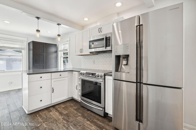 kitchen with dark hardwood / wood-style floors, stainless steel appliances, white cabinetry, and kitchen peninsula