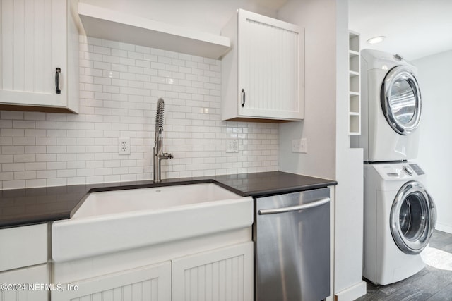 laundry area with stacked washing maching and dryer, sink, and dark hardwood / wood-style floors