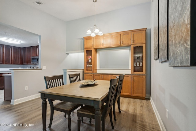 dining area featuring light hardwood / wood-style floors and a chandelier