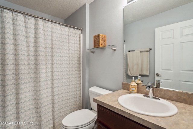 bathroom featuring vanity, a textured ceiling, and toilet