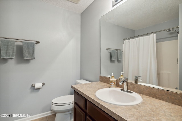 bathroom with tile patterned flooring, toilet, vanity, and a textured ceiling