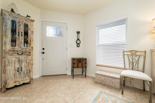 entryway with light tile patterned flooring and baseboards