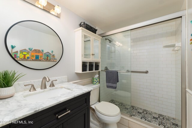 full bath featuring a stall shower, vanity, and toilet