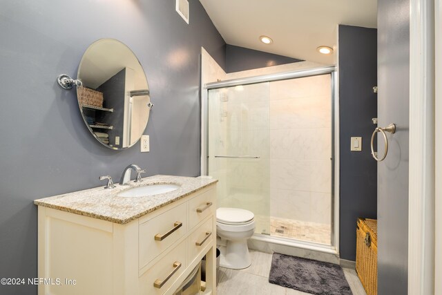 bathroom featuring a shower with door, vanity, toilet, and tile patterned floors