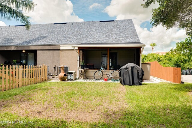 rear view of property featuring a yard