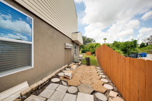 view of home's exterior with fence and stucco siding