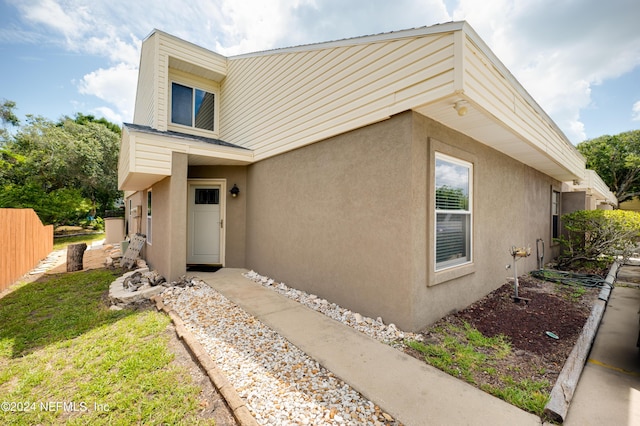 exterior space featuring fence and stucco siding