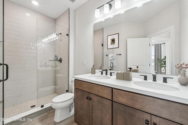 bathroom featuring vanity, toilet, a shower with shower door, and hardwood / wood-style floors