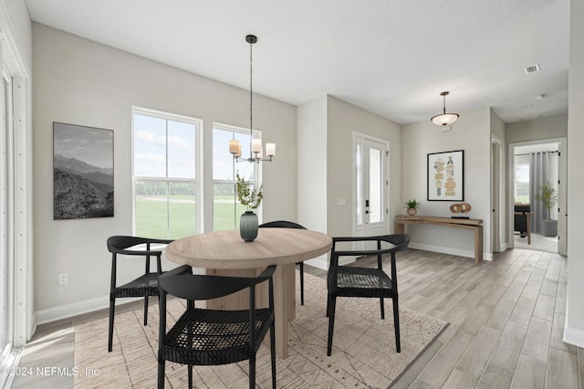 dining space with an inviting chandelier and light wood-type flooring