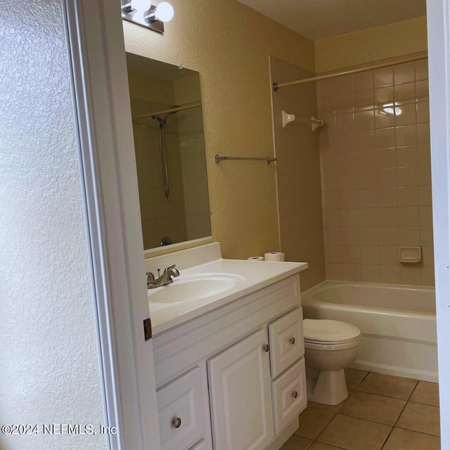 full bathroom with shower / washtub combination, a textured wall, toilet, vanity, and tile patterned flooring