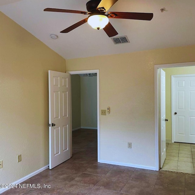 unfurnished bedroom featuring lofted ceiling, ceiling fan, visible vents, and baseboards