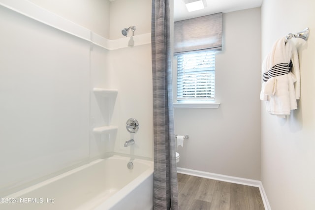 bathroom with toilet, shower / bath combo, and hardwood / wood-style floors