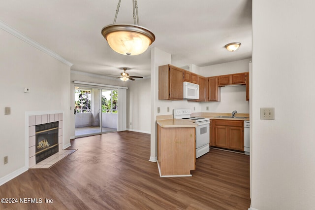 kitchen with a tile fireplace, white appliances, decorative light fixtures, dark hardwood / wood-style flooring, and sink