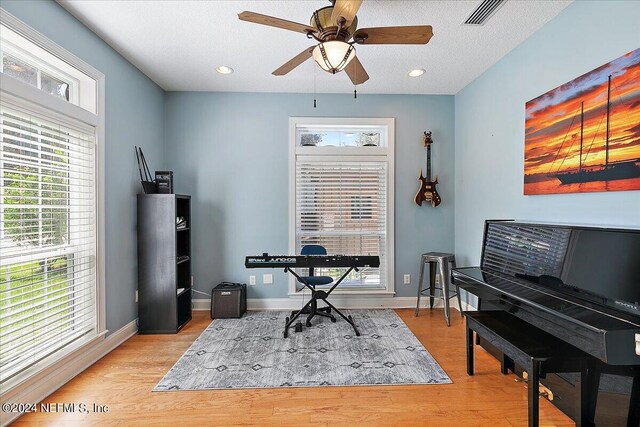 office with plenty of natural light, ceiling fan, a textured ceiling, and light hardwood / wood-style flooring