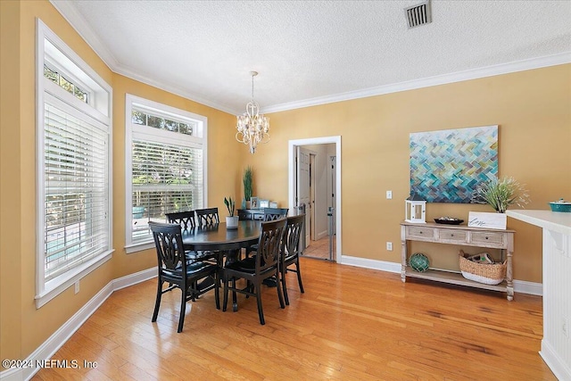 dining area with crown molding, light hardwood / wood-style flooring, and an inviting chandelier