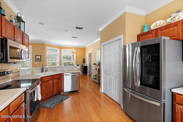 kitchen with tasteful backsplash, stainless steel appliances, sink, light hardwood / wood-style floors, and crown molding