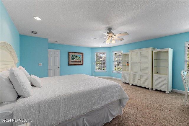 carpeted bedroom with a textured ceiling and ceiling fan