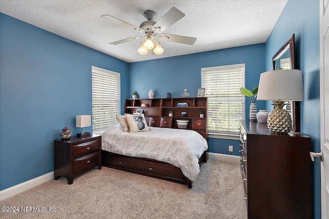 bedroom with a textured ceiling, ceiling fan, and light colored carpet