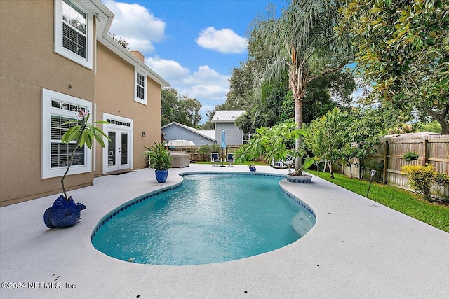 view of swimming pool featuring a patio area and french doors