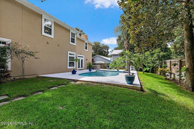 view of pool with a patio and a lawn