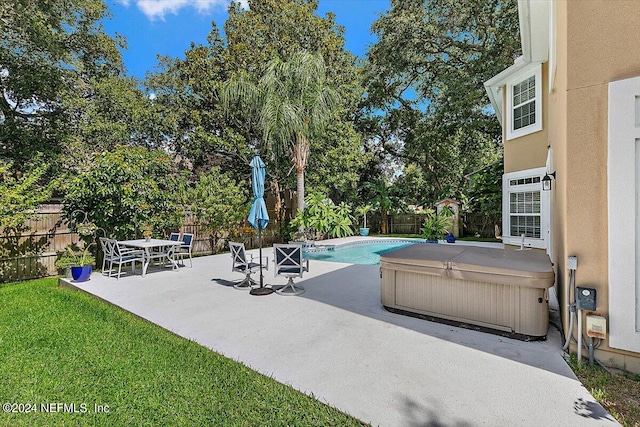 view of patio with a swimming pool with hot tub