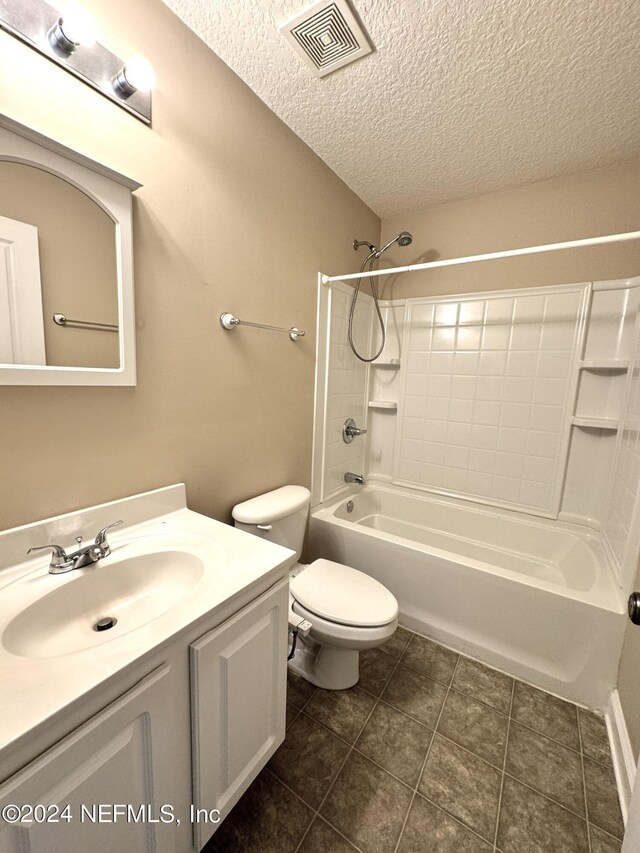 full bathroom with shower / washtub combination, a textured ceiling, tile patterned floors, toilet, and vanity