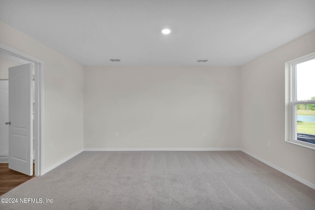 carpeted spare room featuring visible vents, baseboards, and recessed lighting