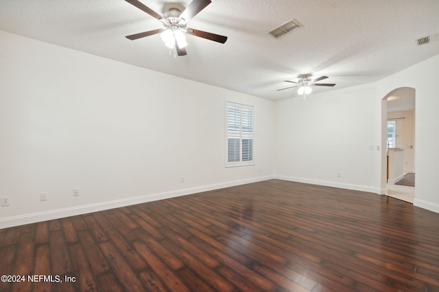 unfurnished room featuring ceiling fan, dark wood-type flooring, and a textured ceiling