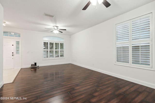 unfurnished room featuring ceiling fan, dark hardwood / wood-style floors, and a textured ceiling