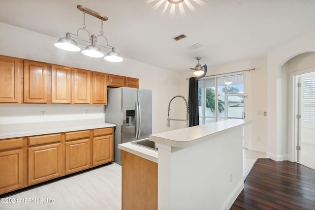 kitchen with decorative light fixtures, a healthy amount of sunlight, stainless steel refrigerator with ice dispenser, and light wood-type flooring