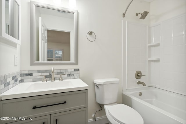 full bathroom featuring washtub / shower combination, toilet, backsplash, and vanity